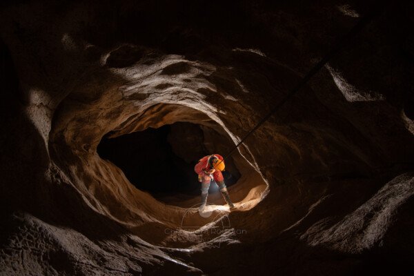 Un spéléo descend l puits de 22 mètres. (Aven du Camelié, Gard)