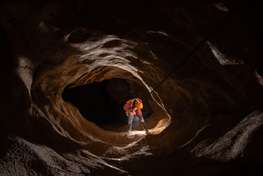 Un spéléo descend l puits de 22 mètres. (Aven du Camelié, Gard)