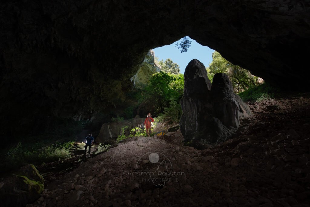 Descente dans l'éboulis. (Baume de Ronze, Ardèche)