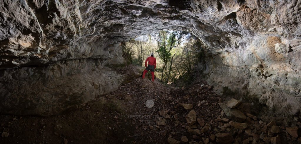 Porche d'entrée de la grotte de Baumas avec un spéléo. (Grotte de Baumas, Ardèche)
