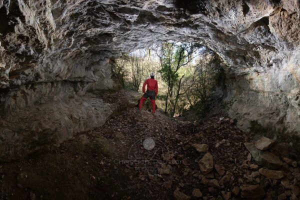 Porche d'entrée de la grotte de Baumas avec un spéléo. (Grotte de Baumas, Ardèche)