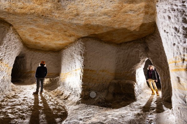 Galeries creusées dans le sable avec deux spéléologues. Par endroit la couche de sable est de couleur ocre. (Tout comme le plafond). (Carrière de Saint-Pancrace, Gard)