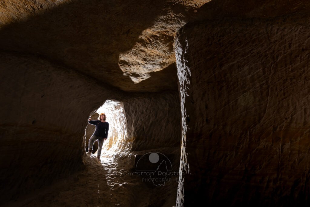 Spéléo dans un petit passage entre deux galeries. (Carrière de Saint-Pancrace, Gard)