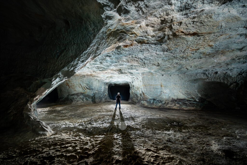 La galerie est colorée par le sulfate de cuivre. (Spéléo au centre). (Carrière de Vallabrègues, Vaucluse)