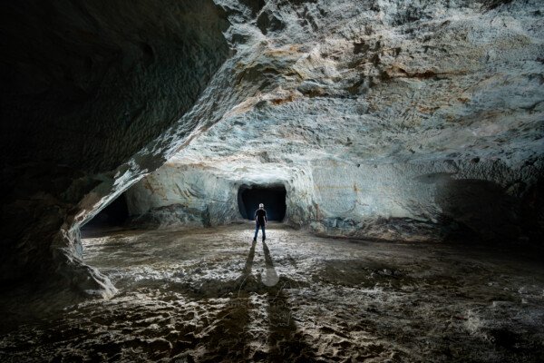 La galerie est colorée par le sulfate de cuivre. (Spéléo au centre). (Carrière de Vallabrègues, Vaucluse)