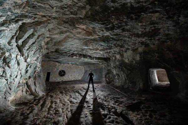 Dans cette galerie, un mur en parpaing avec une turbine permet la ventilation de la champignonnière. (Avec spéléo devant le mur). (Carrière de Vallabrègues, Vaucluse)