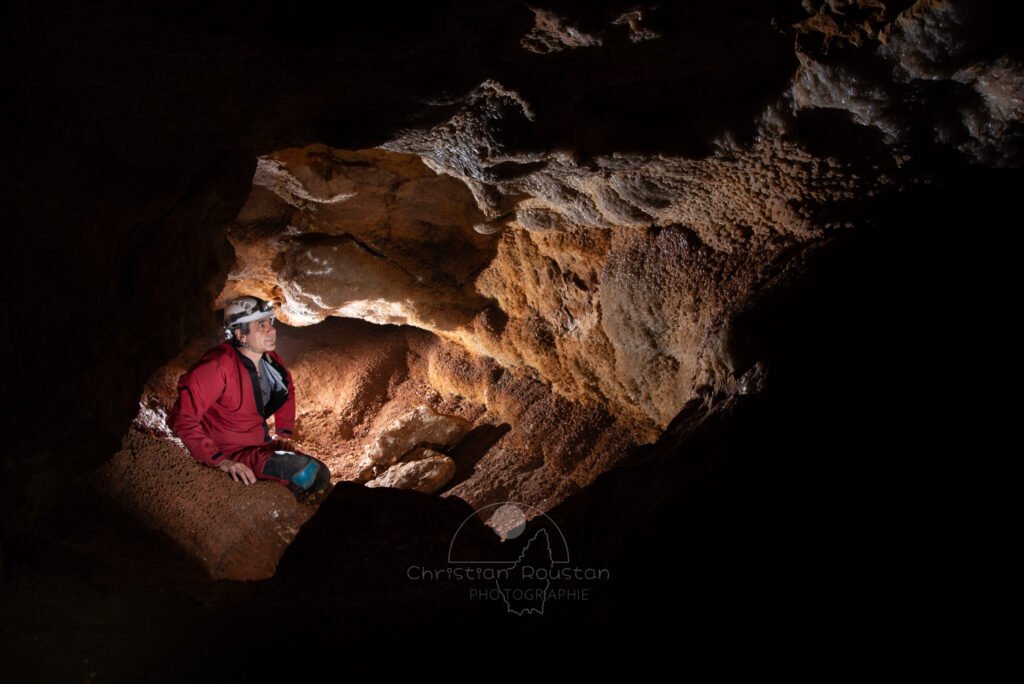 Vue sur cette minuscule salle couverte de cristaux. Le spéléo et photographe Christian Roustan pose sur la photo. (Grotte de Champlong, Ardèche)