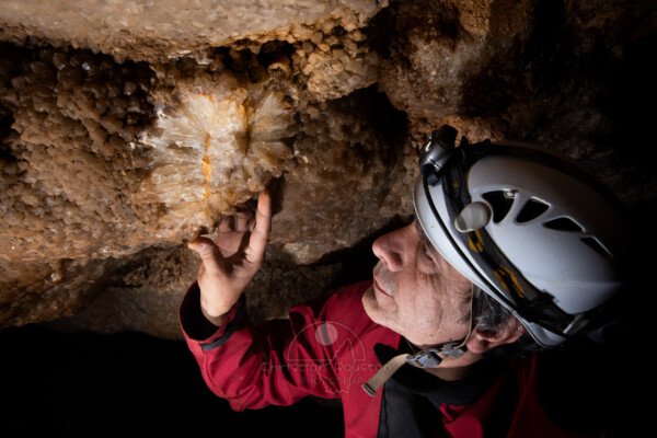 ... c'est triste de voir ça. (Le spéléo en gros plan dans la grotte de Champlong regarde les cristaux cassés) . (Grotte de Champlong, Ardèche)