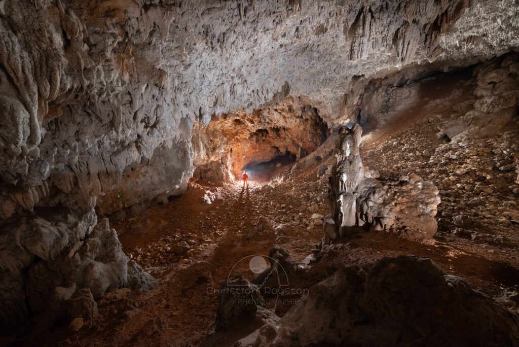 La grande salle avec spéléo au fond qui semble tout petit. (Grotte des Camisards, Gard)