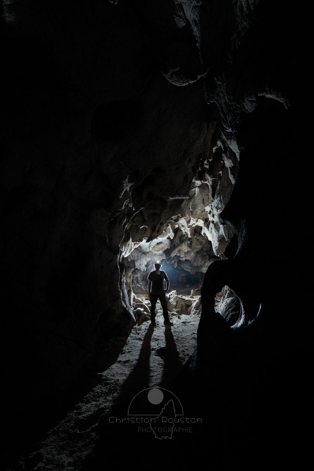 Vision monochrome d'un spéléo dans une galerie. (Grotte des Fées, Ardèche)