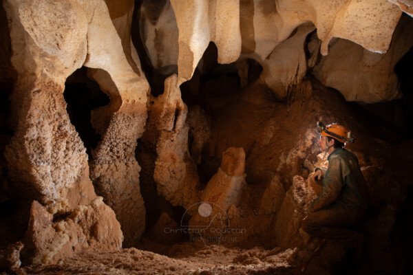 Des cristaux dans un gour asséché avec spéléo au bord. (Grotte du Barry, Gard)
