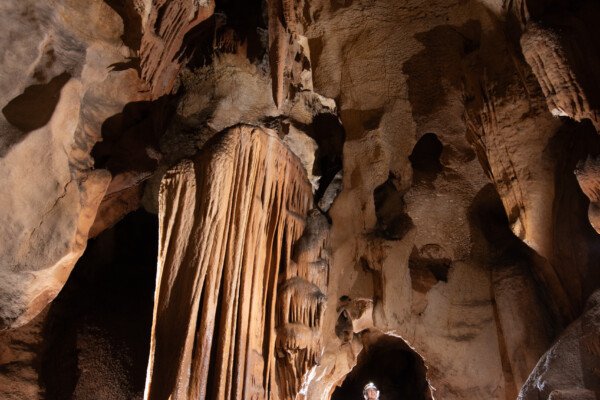 Spéléo dans la grande du Barry, le passage entre les concrétions ressemble à une porte.. (Grotte du Barry, Gard)