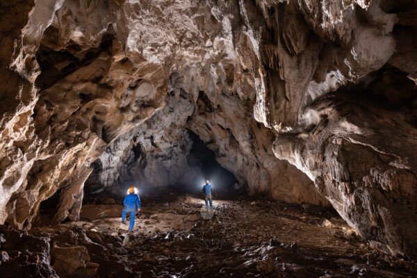 Deux spéléo en bleu dans la grotte du Déroc. (Grotte du Déroc, Ardèche)