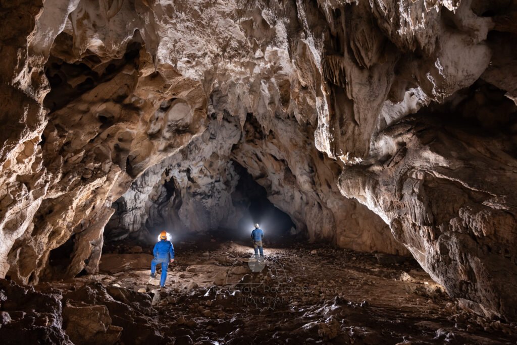 Deux spéléo en bleu dans la grotte du Déroc. (Grotte du Déroc, Ardèche)