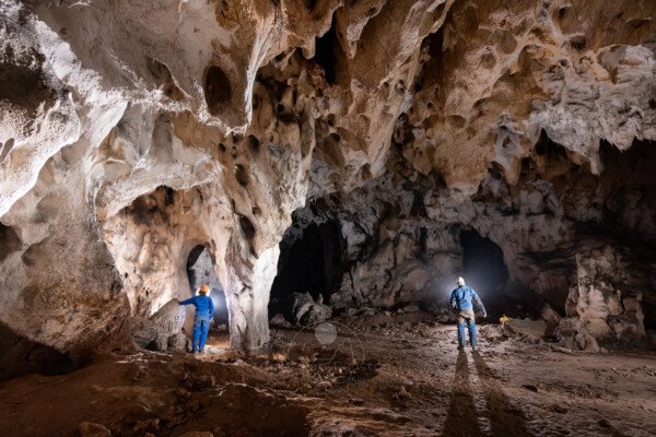 Deux spéléo en bleu dans la grotte du Déroc. (Grotte du Déroc, Ardèche)