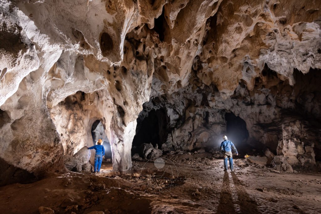 Deux spéléo en bleu dans la grotte du Déroc. (Grotte du Déroc, Ardèche)