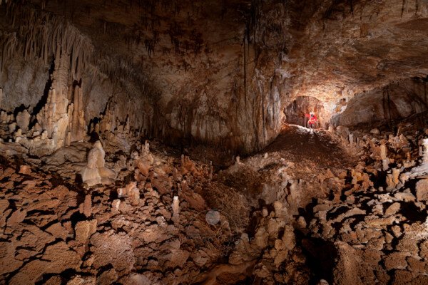 La première salle avec un spéléo à la base du puits d'entrée. (Aven Grotte de l'Émeraude, Gard)