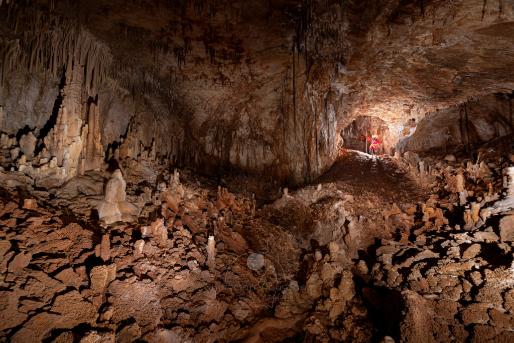 La première salle avec un spéléo à la base du puits d'entrée. (Aven Grotte de l'Émeraude, Gard)