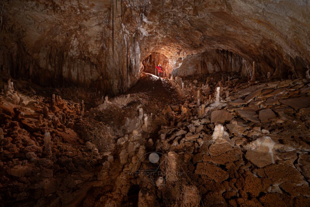 La première salle avec un spéléo à la base du puits d'entrée. (Aven Grotte de l'Émeraude, Gard)
