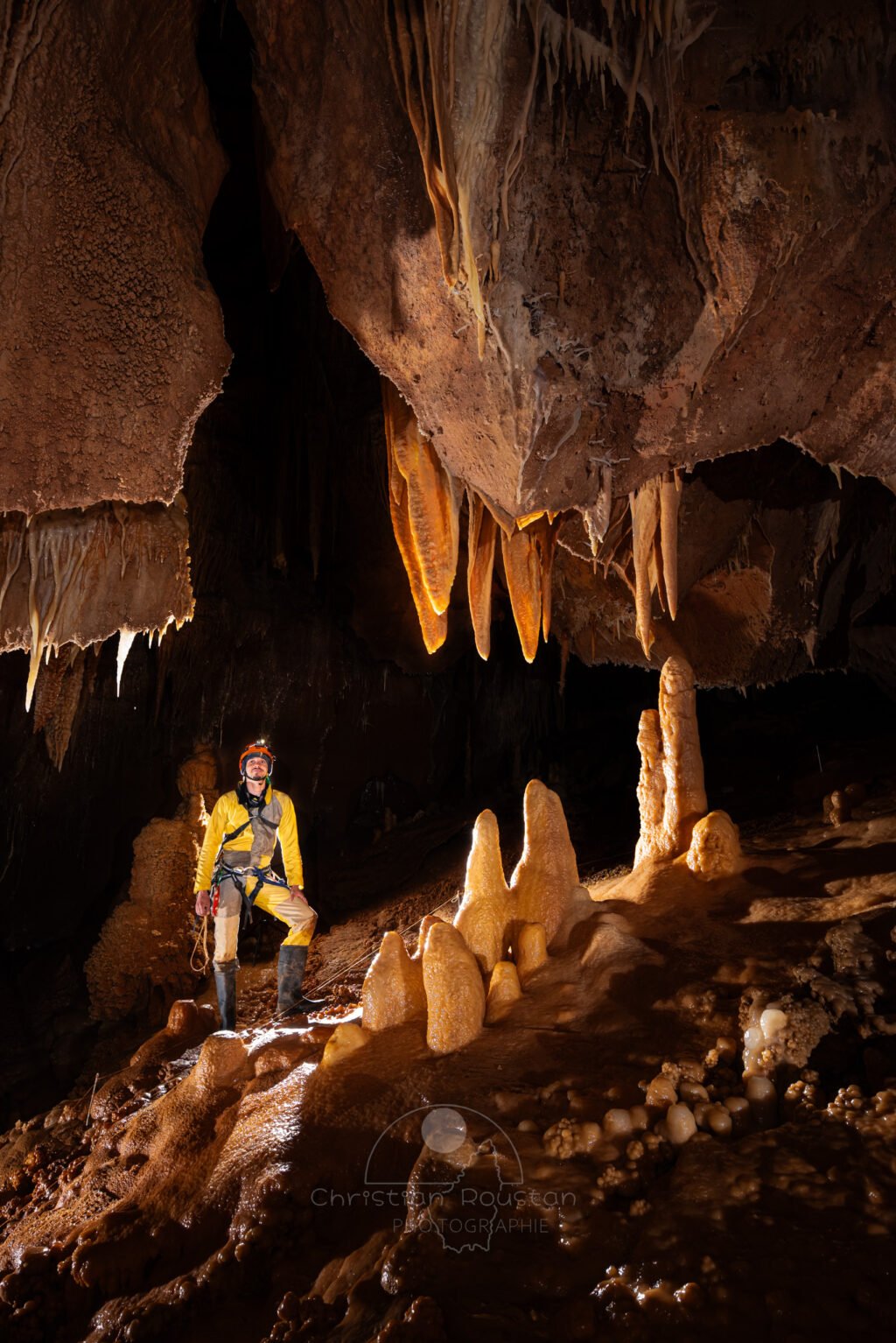 Spéléo à coté d'un massif de concrétion. (Aven Grotte de l'Émeraude, Gard)