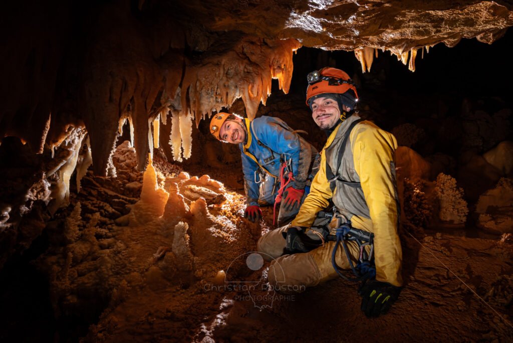 Deux spéléologues souriants en pleine contemplation. (Spéléothème) (Aven Grotte de l'Émeraude, Gard)