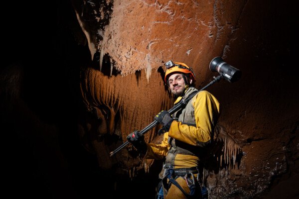 Un spéléo porte un flash sur l'épaule. (Aven Grotte de l'Émeraude, Gard)