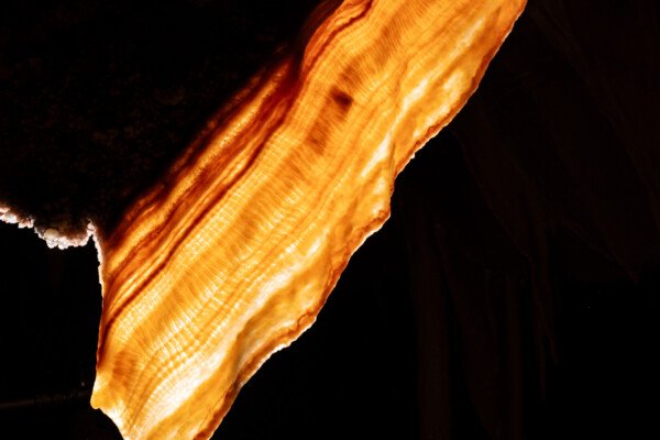 Une draperie éclairée par transparence. (Spéléothème) (Aven Grotte de l'Émeraude, Gard)