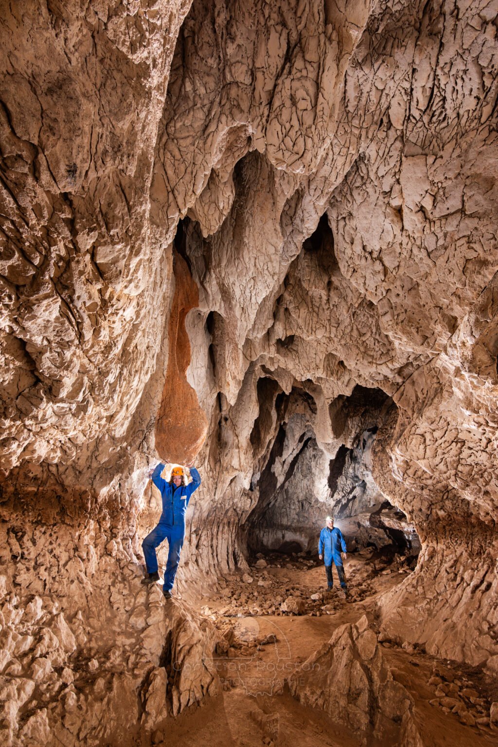 Deux spéléo dans la zone terminale de la galerie et sa coulée ocre sur la gauche (Grotte de Louoï, Ardèche)