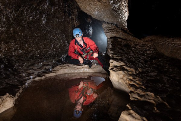 Reflet d'un spéléo dans une marmite (Évent de Peyrejal, Ardèche)