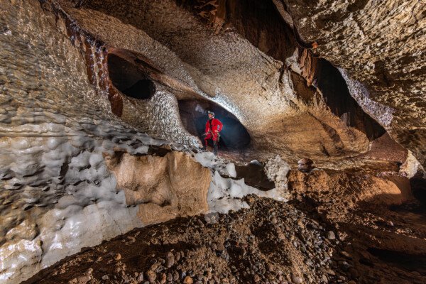 Un profil de galerie à 45°. Du sable et des galets au premier plan (Évent de Peyrejal, Ardèche)