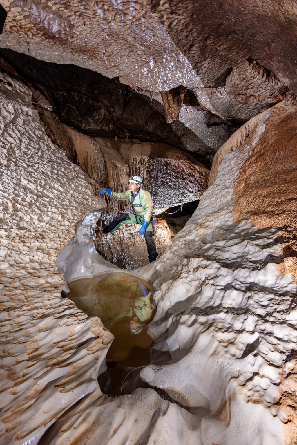 Petit passage en main courante avec reflet du spéléo dans une vasque (Évent de Peyrejal, Ardèche)