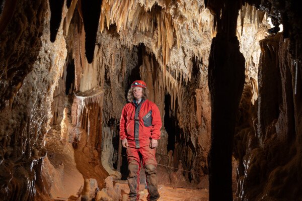 Galerie concrétionnée avec spéléo (Grotte de la Barbette, Réseau Estevan, Gard)