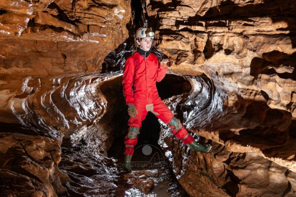 Profil de galerie avec banquette avec un spéléo en opposition (Grotte de Pézenas, Ardèche)