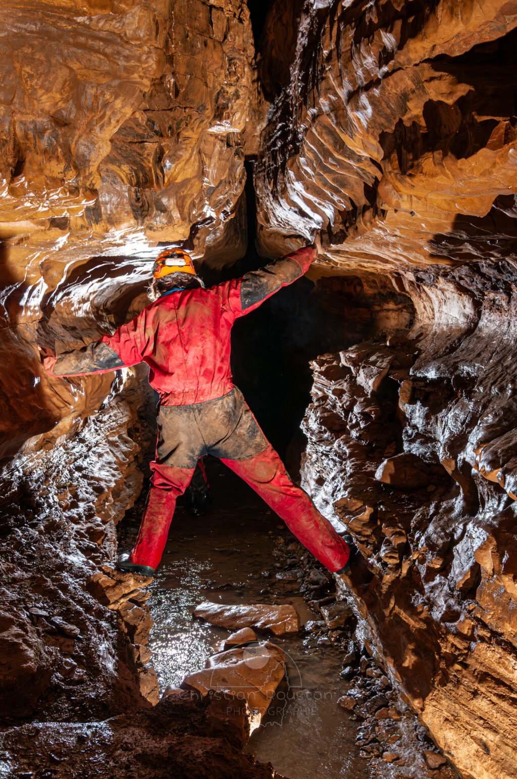 Profil de galerie avec banquette avec un spéléo en opposition (Grotte de Pézenas, Ardèche)