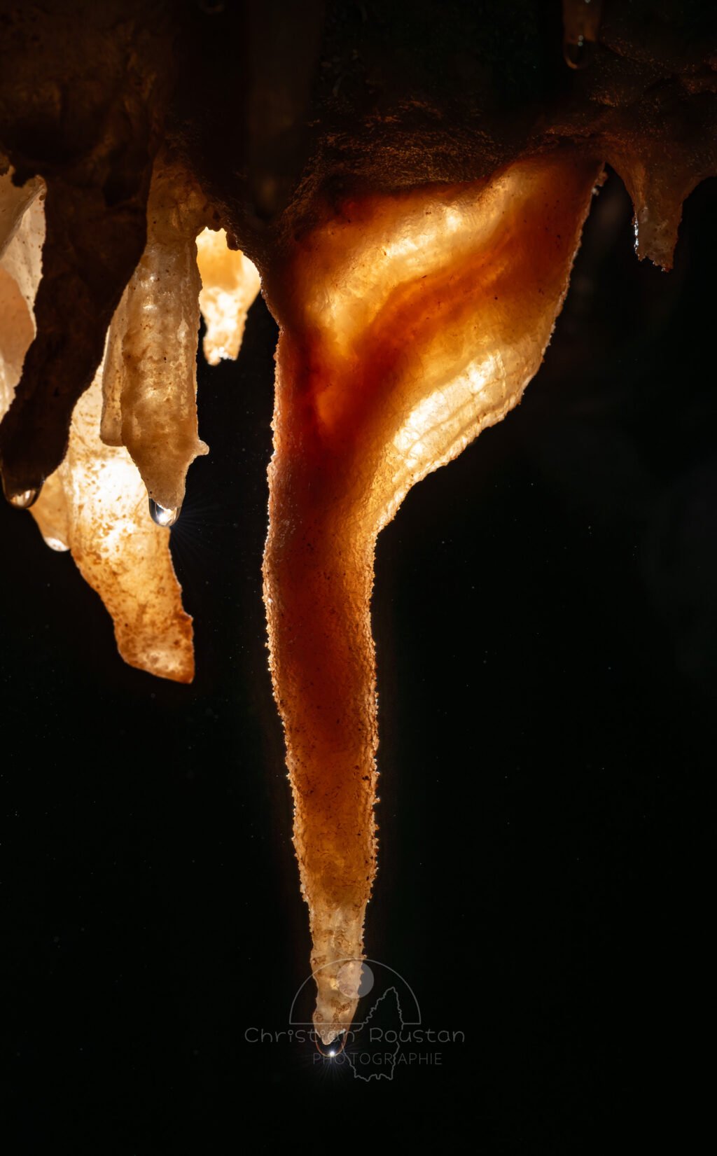 Draperie se prolongeant par une stalactite à la structure cristalline (Spéléothème, Grotte du Philosophe, Gard)