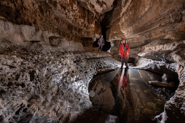 Une grande marmite proche de l'entrée avec deux spéléologues (Spéléo, Goule de Sauvas, Ardèche)