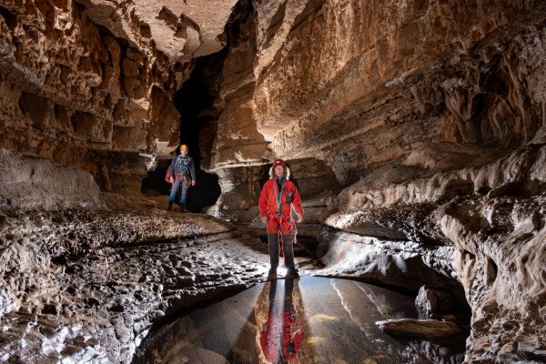 Une grande marmite proche de l'entrée avec deux spéléologues (Spéléo, Goule de Sauvas, Ardèche)