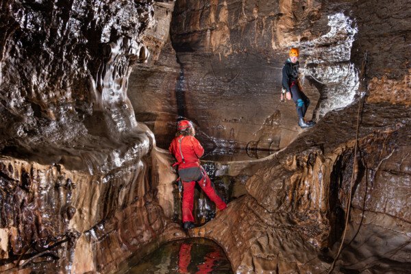 Passage de la main courante au dessus de la grande marmite (Spéléo, Goule de Sauvas, Ardèche)