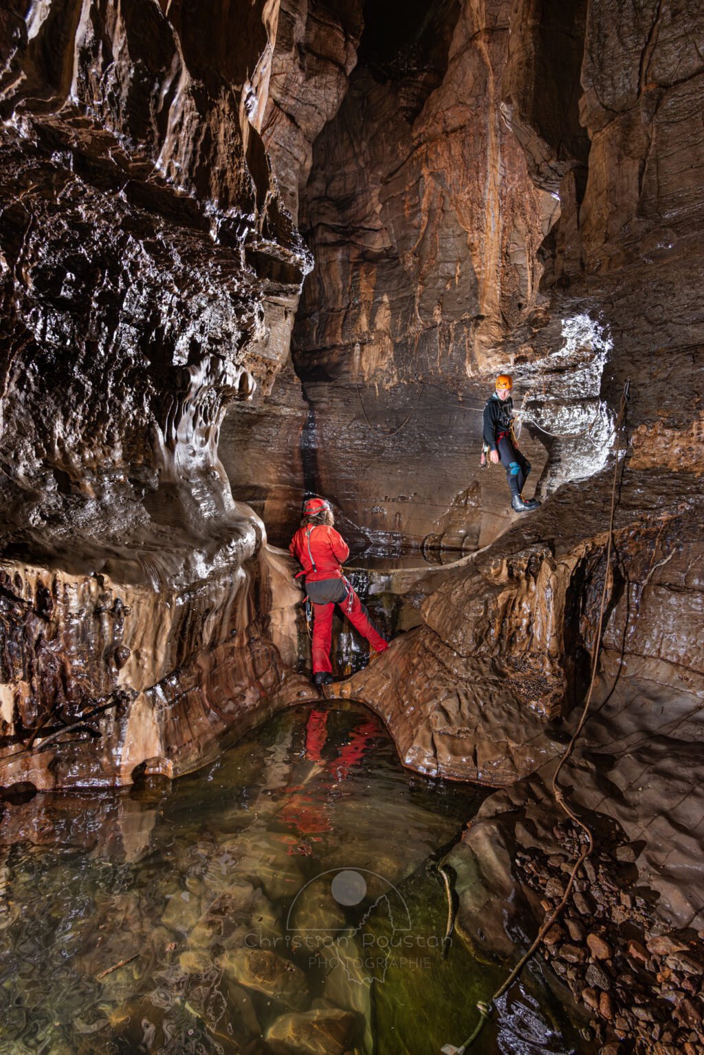 Passage de la main courante au dessus de la grande marmite (Spéléo, Goule de Sauvas, Ardèche)