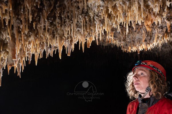 Spéléo qui regarde le plafond richement concrétionné (Spéléo, Grotte du Prevel, Gard)